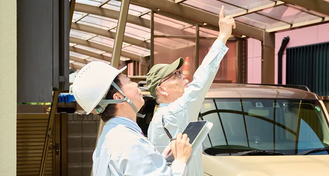 建築施工管理技士がモニターで屋根の状態を説明している様子